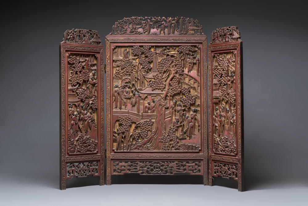 A Chinese carved gilt-lacquered wooden three-panel folding screen with a narrative design, 19/20th C.