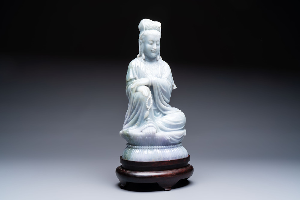 An exceptional and large Chinese carved pale lavender jadeite Guanyin on a wooden stand, Republic