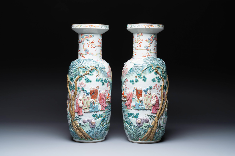 A pair of Chinese famille rose '18 Luohan' vases with relief design, 19th C.