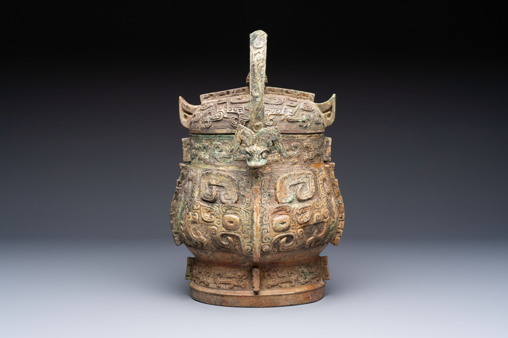 A Chinese archaic bronze wine vessel and cover with Taotie design, You 卣, late Shang
