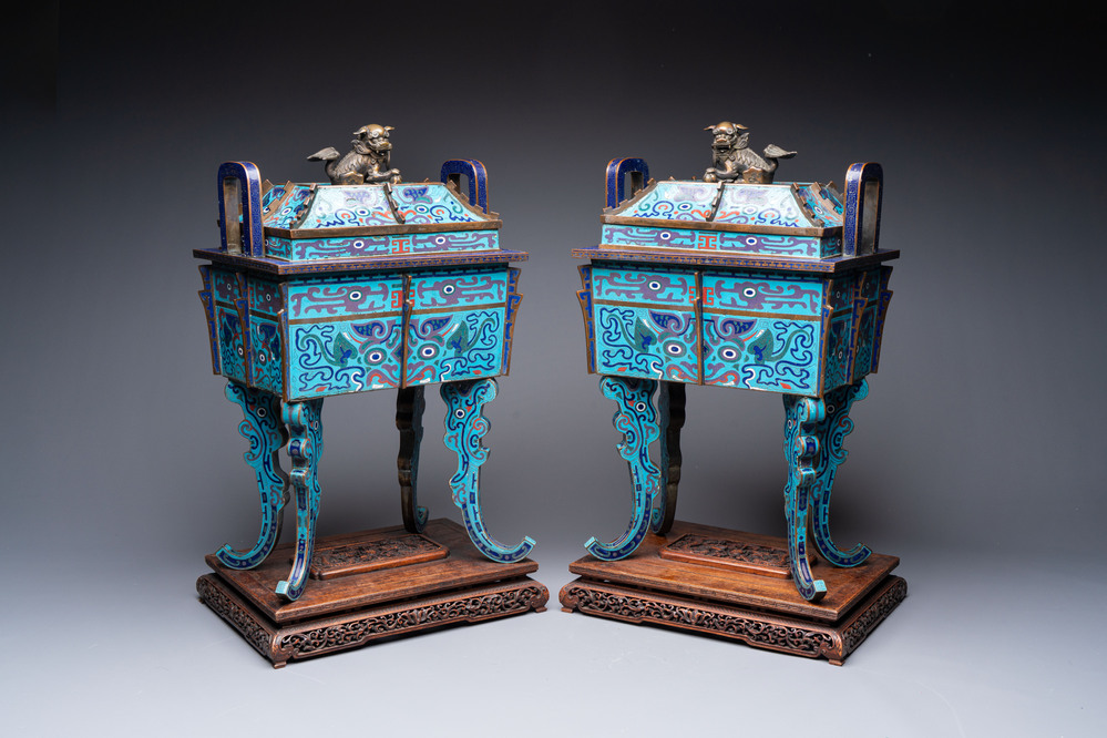 A pair of Chinese cloisonn&eacute; 'Fangding' censers and covers with Taotie design on carved wooden stands, 19th C.