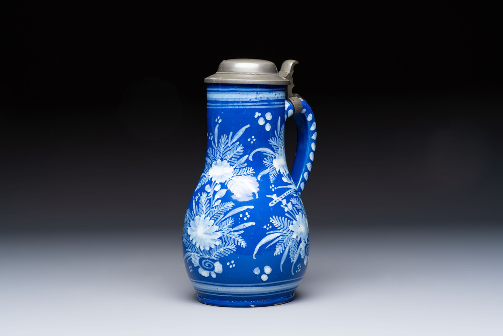 A Nevers white-decorated Persian-blue-ground faience jug with a mounted pewter lid, France, 18th C.
