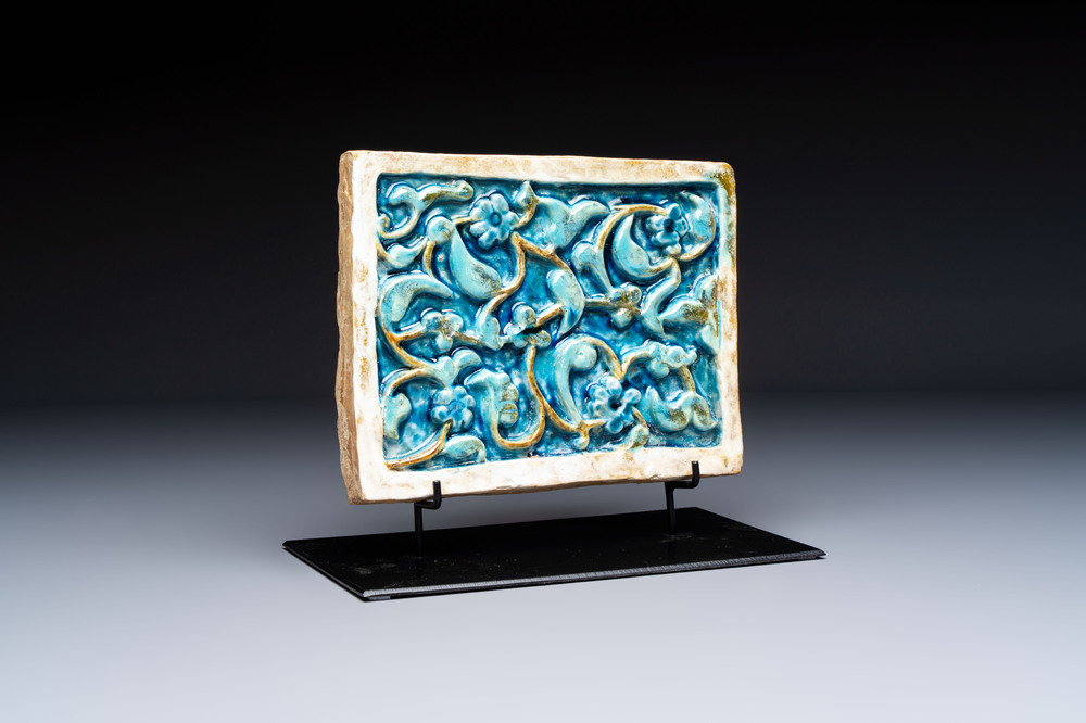A Timurid polychrome-glazed rectangular tile with foliage design, on a later metal stand, Central Asia, 14th C.