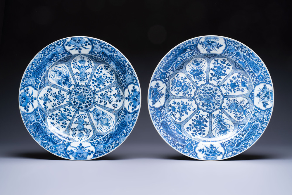 A pair of large Chinese blue and white 'Peacock Border' chargers with floral design, Kangxi