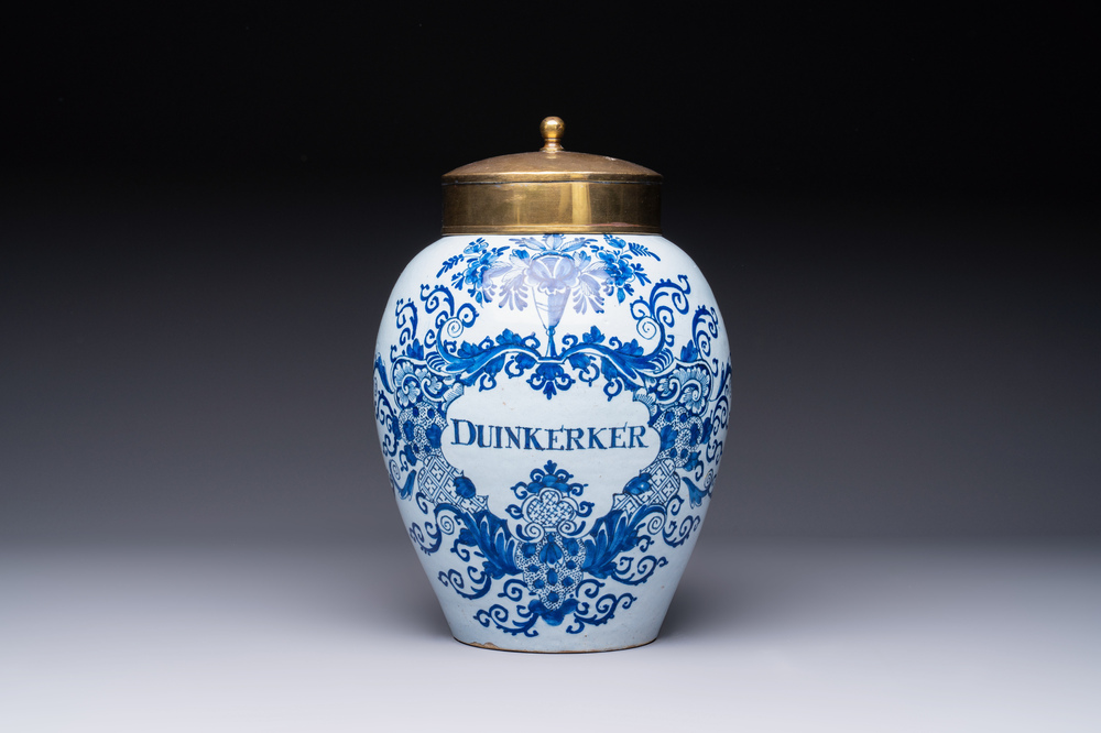 A blue and white Dutch Delft tobacco jar inscribed 'Duinkerker' with brass lid, 18th C.