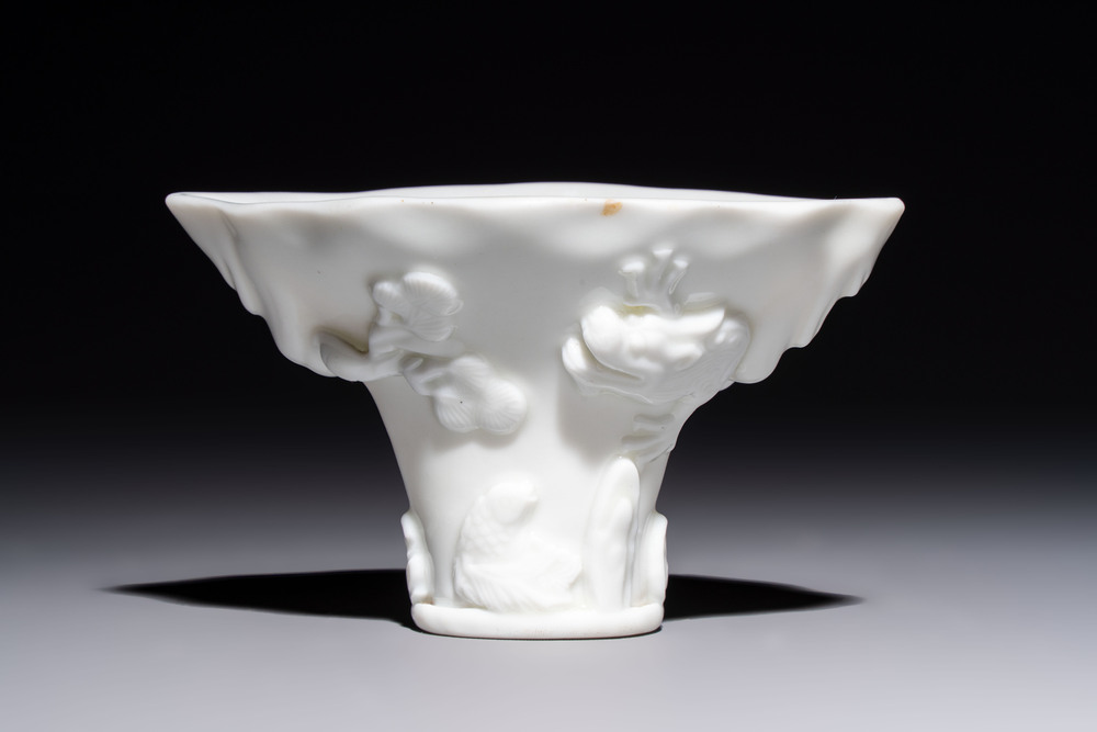 A Chinese Dehua blanc de Chine 'Dragon, Carp, Crane and Deer' libation cup, Kangxi