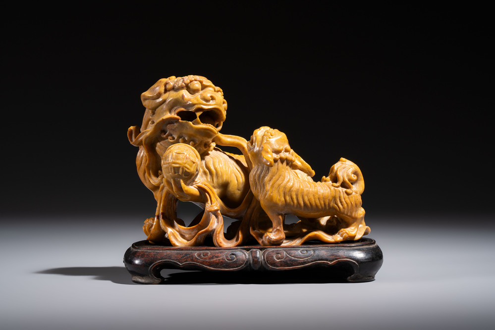 A fine Chinese soapstone group of Buddhist lions on wooden stand, 19th C.