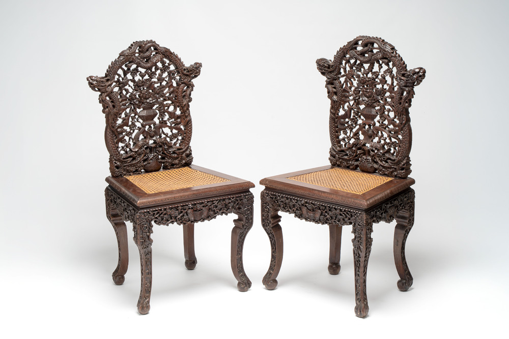 A pair of richly carved Chinese hongmu 'Dragon' chairs with cane seats, 19th C.