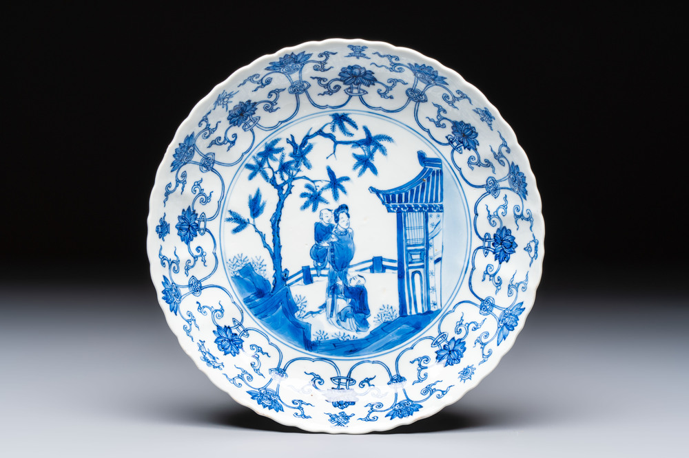 A Chinese blue and white 'Elegant Lady with Two Boys' plate with a 'Lotus Scroll' border, Kangxi