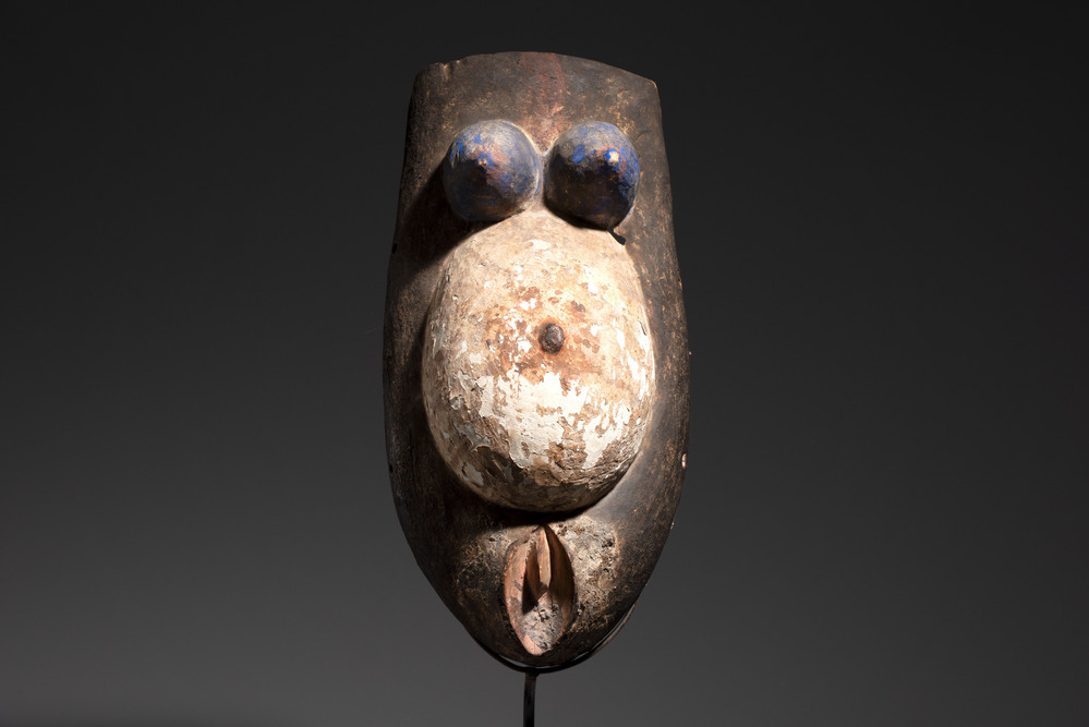 A polychromed wooden fertility belly mask from the Yoruba people, West Africa, 20th C.