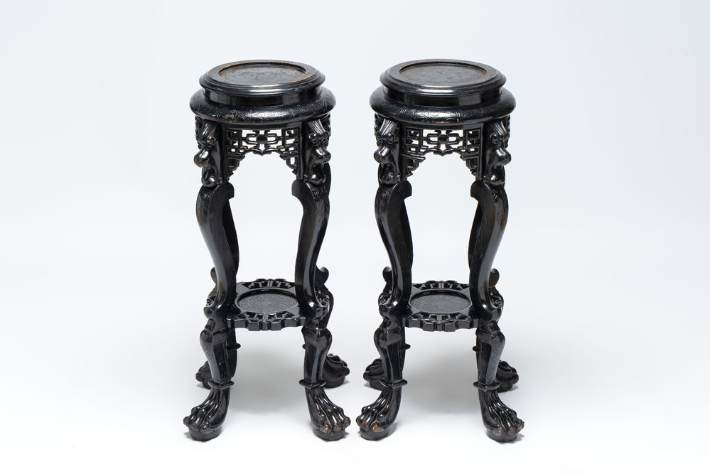 A pair of black-lacquered carved wood chinoiserie stands on lion feet, 19th C.