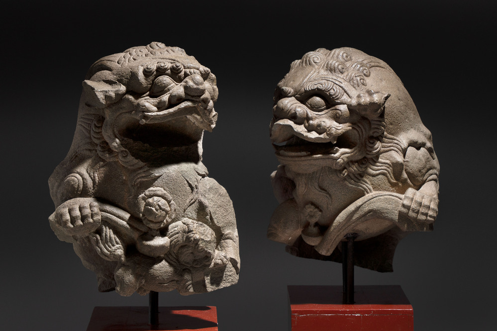 A pair of Chinese carved stone Buddhist lions on later red-lacquered wooden stands, Fujian, Qing
