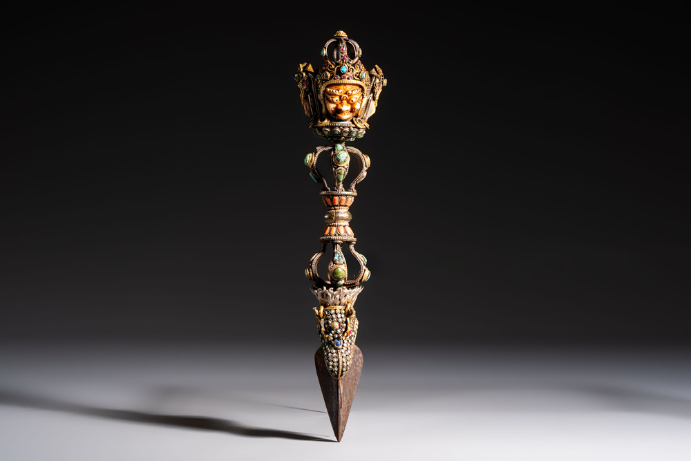 A Tibetan parcel-gilt silver and iron phurba inlaid with precious stones, red coral and bone, 19th C.