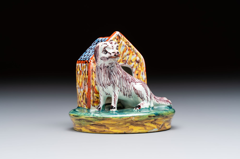 A rare polychrome Dutch Delft sculpture of a dog in front of its kennel, 18th C.