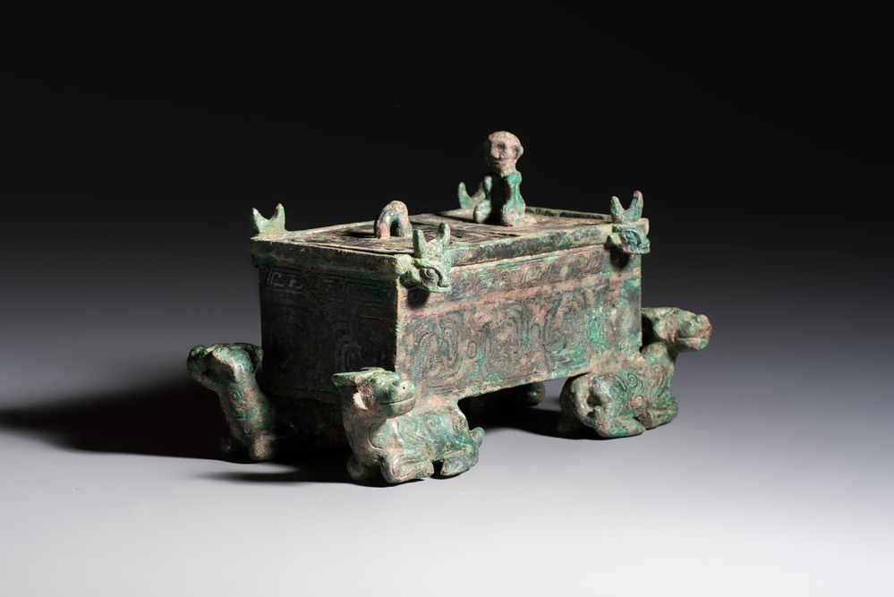 A Chinese archaic bronze cosmetic box standing on four stylised buffalo-form feet, Lian 奩, Eastern Zhou/Spring and Autumn