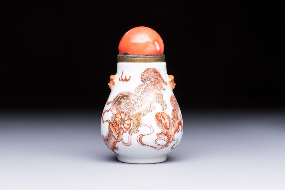 A Chinese gilt-decorated iron-red 'Buddhist Lions' snuff bottle with a red coral stopper, Buddhist Lion mark, Republic