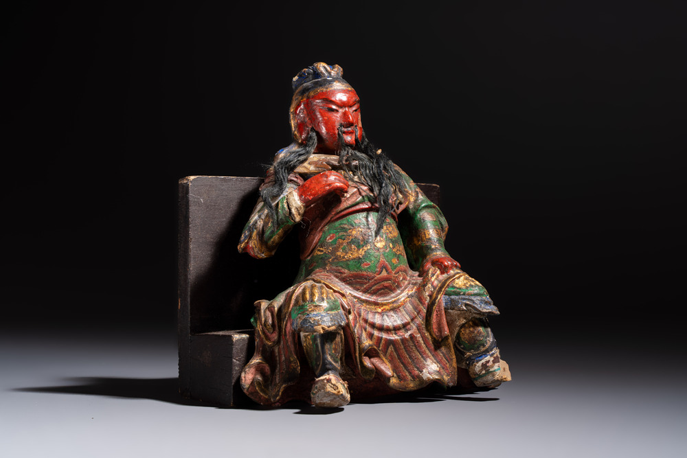 A Chinese gilt and polychrome lacquered papier-m&acirc;ch&eacute; and wooden Guandi on a wooden stand, 19th C.