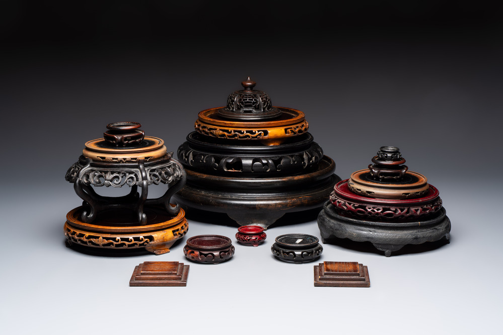A Chinese reticulated wooden cover and 17 wooden stands, 19/20th C.