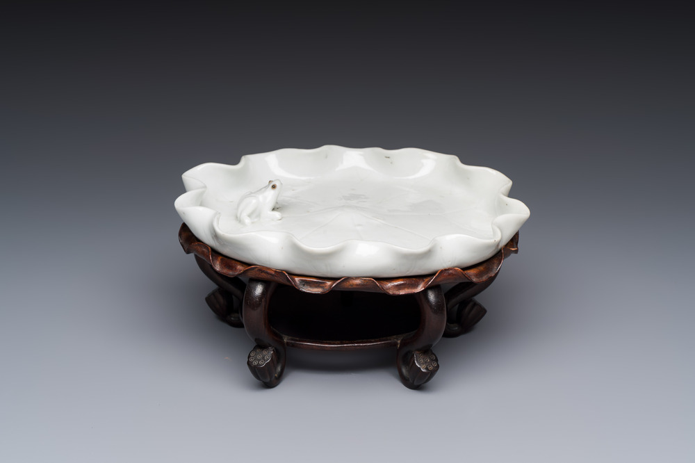 A Chinese Dehua blanc de Chine 'Lotus Leaf and Frog' brush washer on a wooden stand, Kangxi/Yongzheng