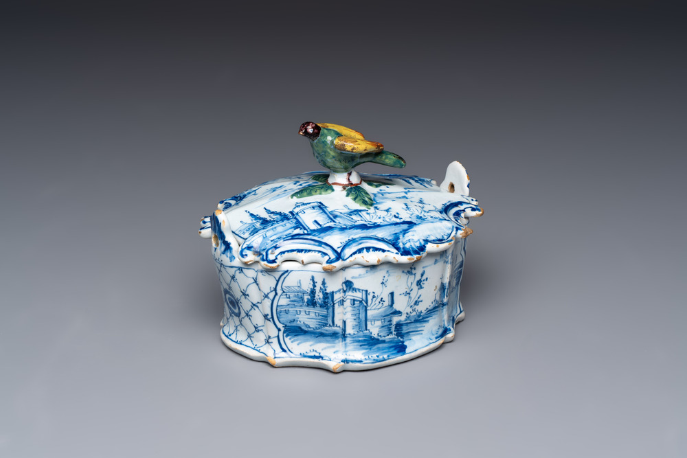 A blue and white Dutch Delft butter tub with a polychrome bird-shaped finial, 18th C.