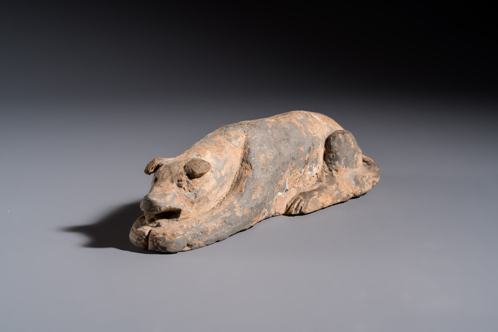 A Chinese grey pottery model of a reclining dog, Han