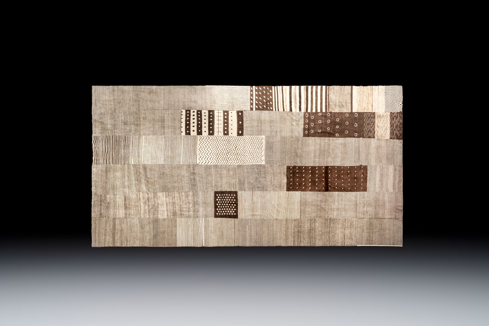 A very large Persian hand-knotted woollen carpet with a geometric patchwork design, 20th C.