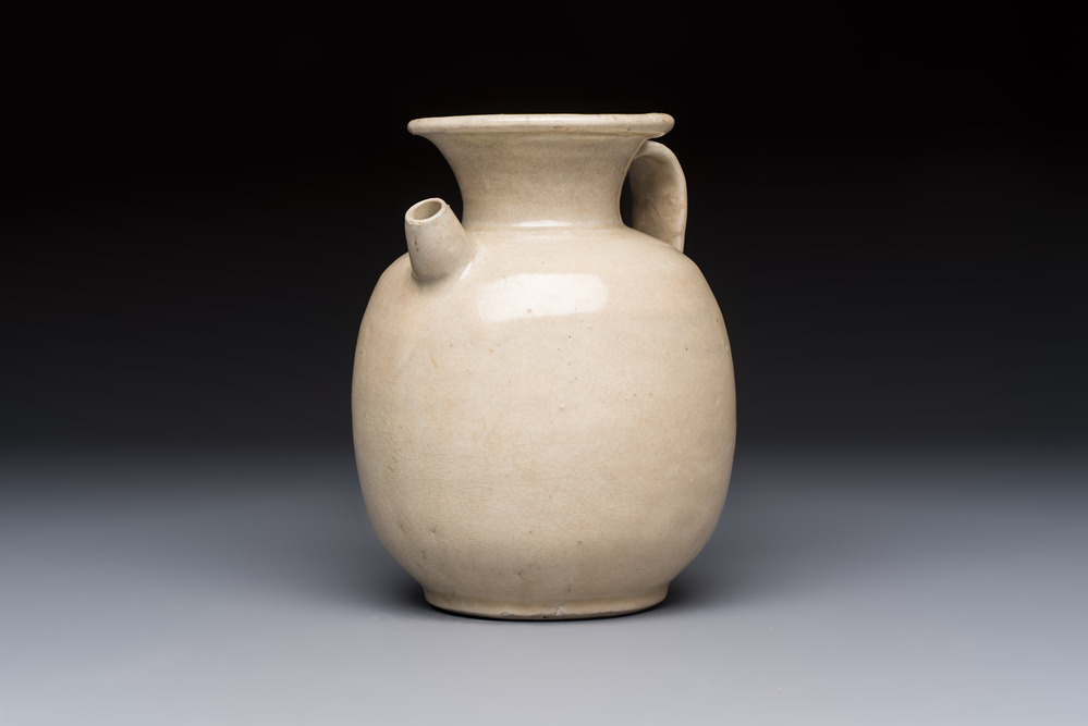 A Chinese cream-glazed ewer with a barrel-shaped body, Hebei/Henan provinces, Tang/Five Dynasties