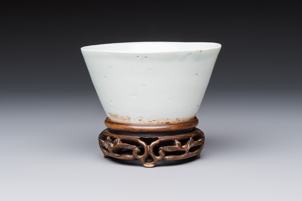 A Chinese white-glazed cup on a wooden stand, 17th C.