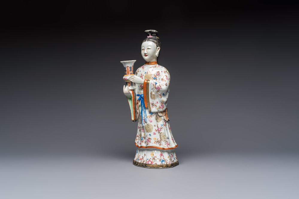 A Chinese famille rose candle holder in the shape of a court lady holding a 'Gu' vase, Qianlong