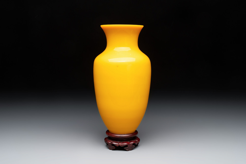 A Chinese yellow Peking glass vase on a wooden stand, 19th C.