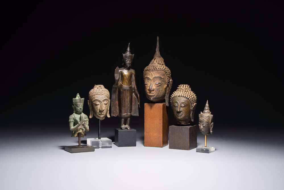 A bronze standing Buddha, a torso of Buddha and four heads of Buddha, Thailand, 17/18th C.
