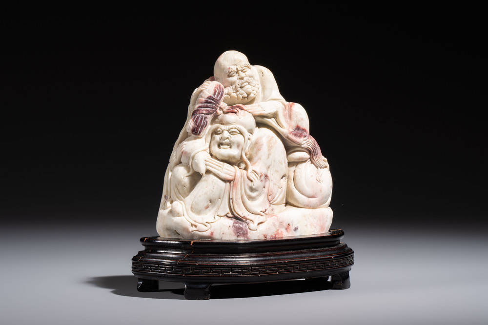 A Chinese carved soapstone 'Luohan' group on a wooden stand, Republic