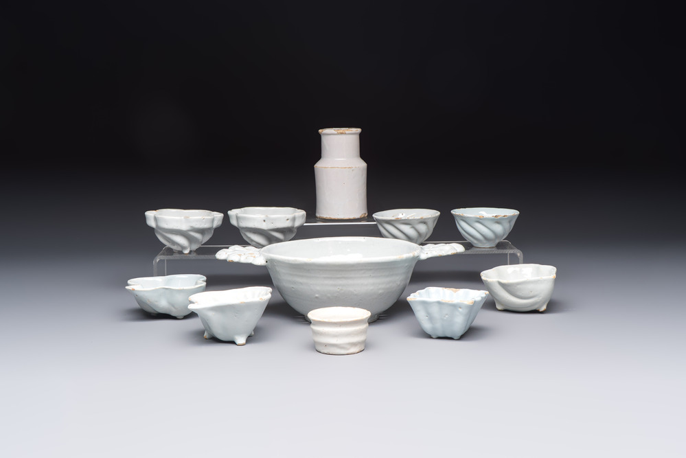 A collection of nine white-glazed Dutch Delft pudding moulds, a mustard pot and a two-handled strainer, 18th C.