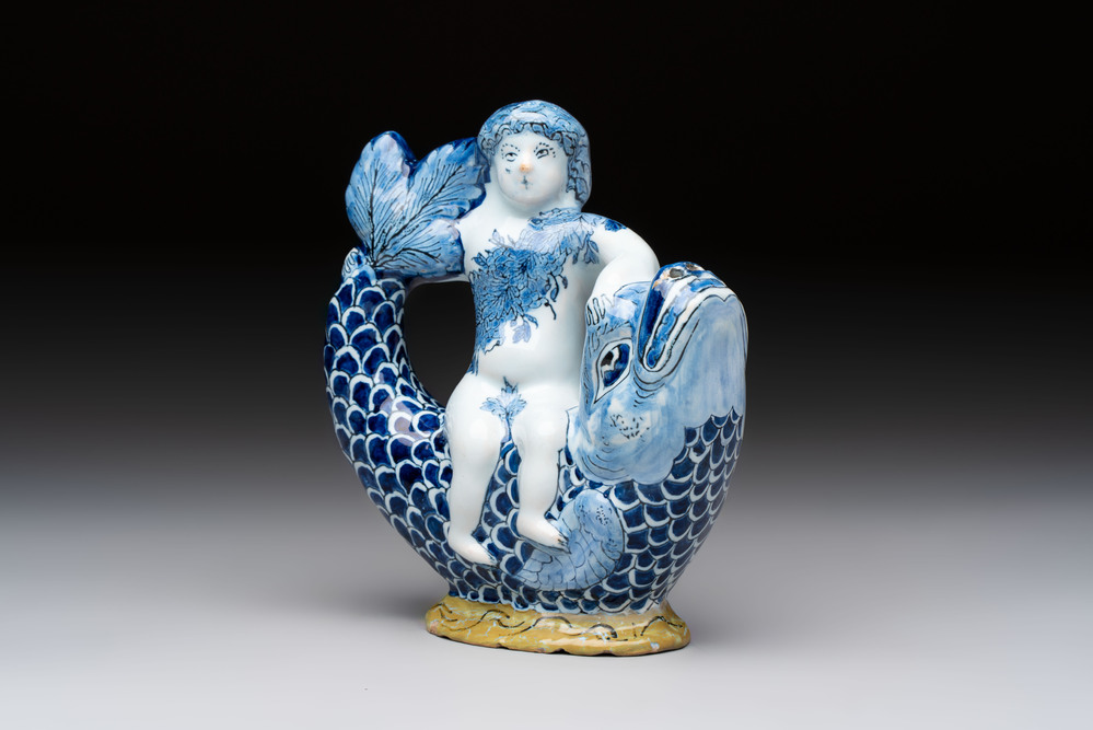 A blue and white Dutch Delft ewer in the shape of a putto on a dolphin on a wavy green ground, 18th C.