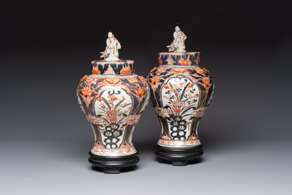 A pair of Japanese Imari baluster vases and covers on wooden stands, Edo, 18th C.