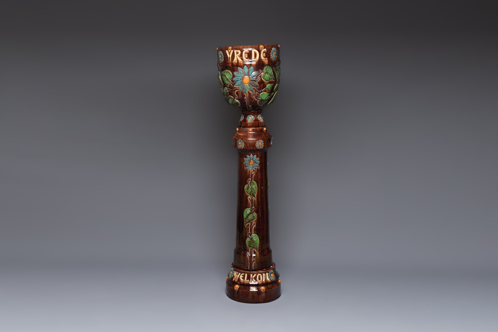 A very large Art Nouveau Flemish pottery four-piece jardini&egrave;re and stand, inscribed 'VREDE' and 'WELKOM', early 20th C.