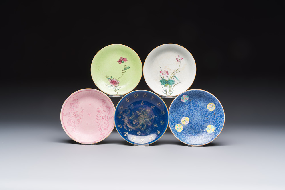 Four Chinese famille rose saucers and a gilt-decorated powder-blue-ground saucer, Qianlong and Jiaqing marks, 18/19th C.