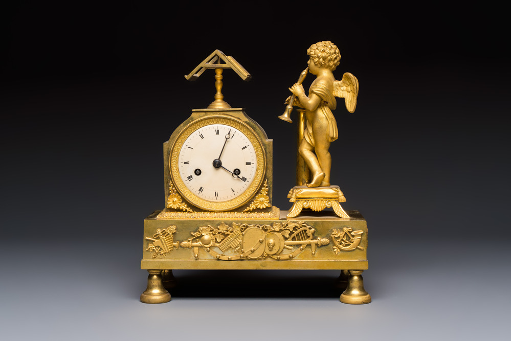 A French fire-gilt mantel clock with a music making cherub, early 19th C.