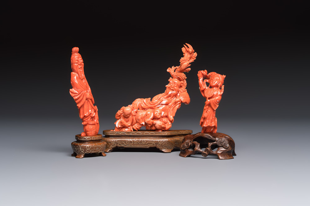 Three Chinese red coral carvings on wooden stands, 19/20th C.