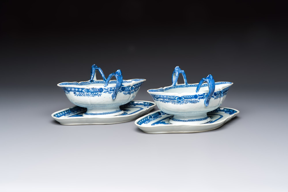 A pair of Chinese blue and white handled sauce boats and stands with pagodas along a river, Qianlong