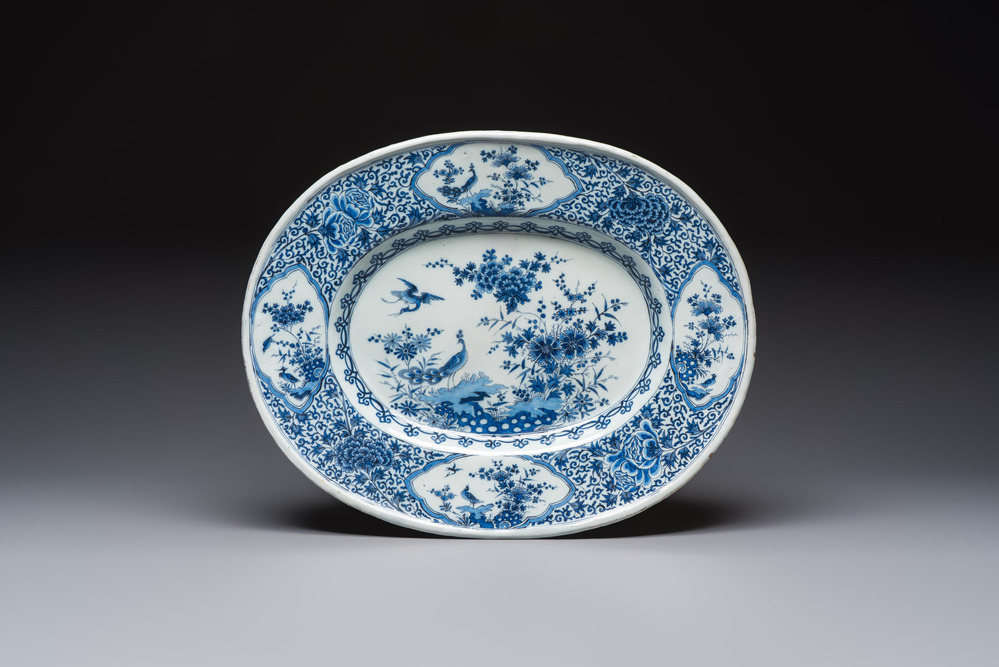 A very rare and massive blue and white Dutch Delft dish with peacocks in a garden, late 17th C.