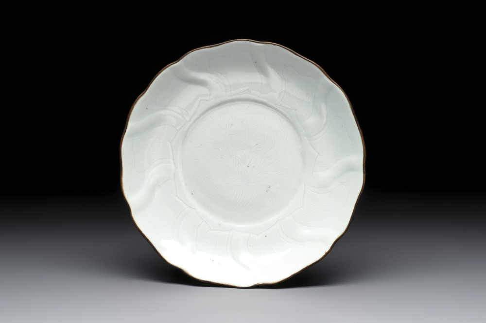 A Chinese moulded white-glazed plate with anhua floral design and a copper-mounted rim, Xuande mark, late Ming