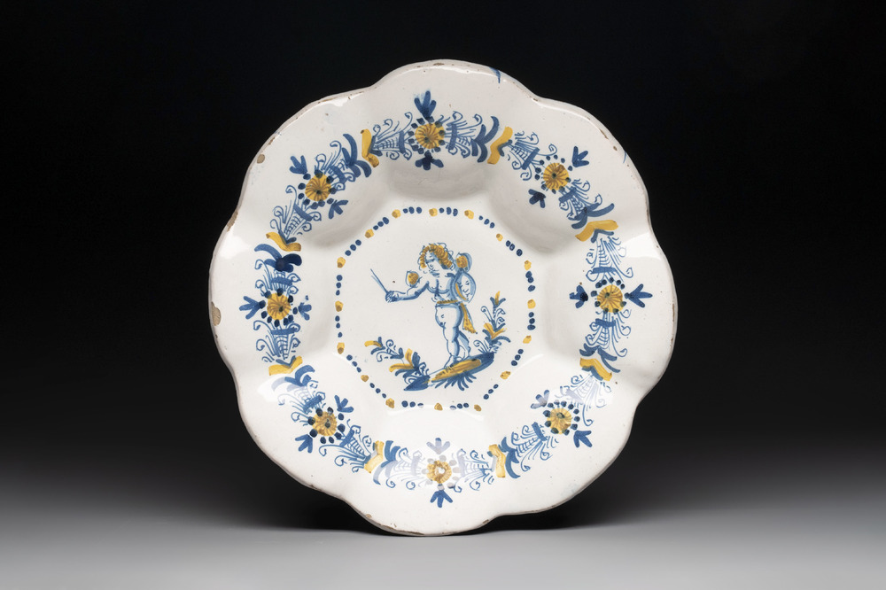 A blue, white and yellow Dutch Delftware dish with a putto, Delft or Haarlem, 17th C.