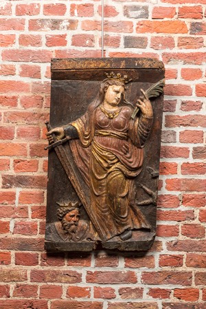 Een Spaans polychroom eikenhouten paneel met Catharina van Alexandrië en keizer Maxentius, 17e eeuw