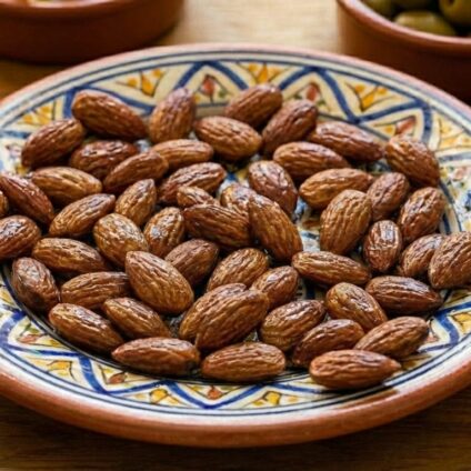 Saltrostade mandlar upplagda på ett keramikfat.